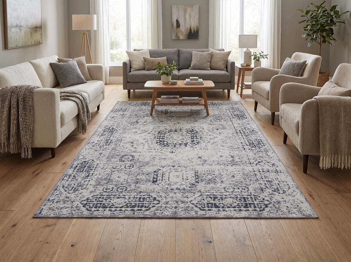 Orné de motifs patinés ivoire et gris, ce tapis rectangulaire en laine habille un salon lumineux