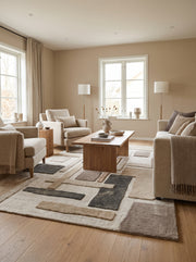 Sculpté en laine tuftée, ce tapis rectangulaire aux blocs ivoire, sable, taupe, brun et anthracite décore un salon