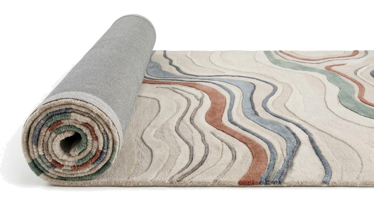 Rouleau de tapis en laine ivoire et terracotta révélant son envers tissé gris et son relief sculpté