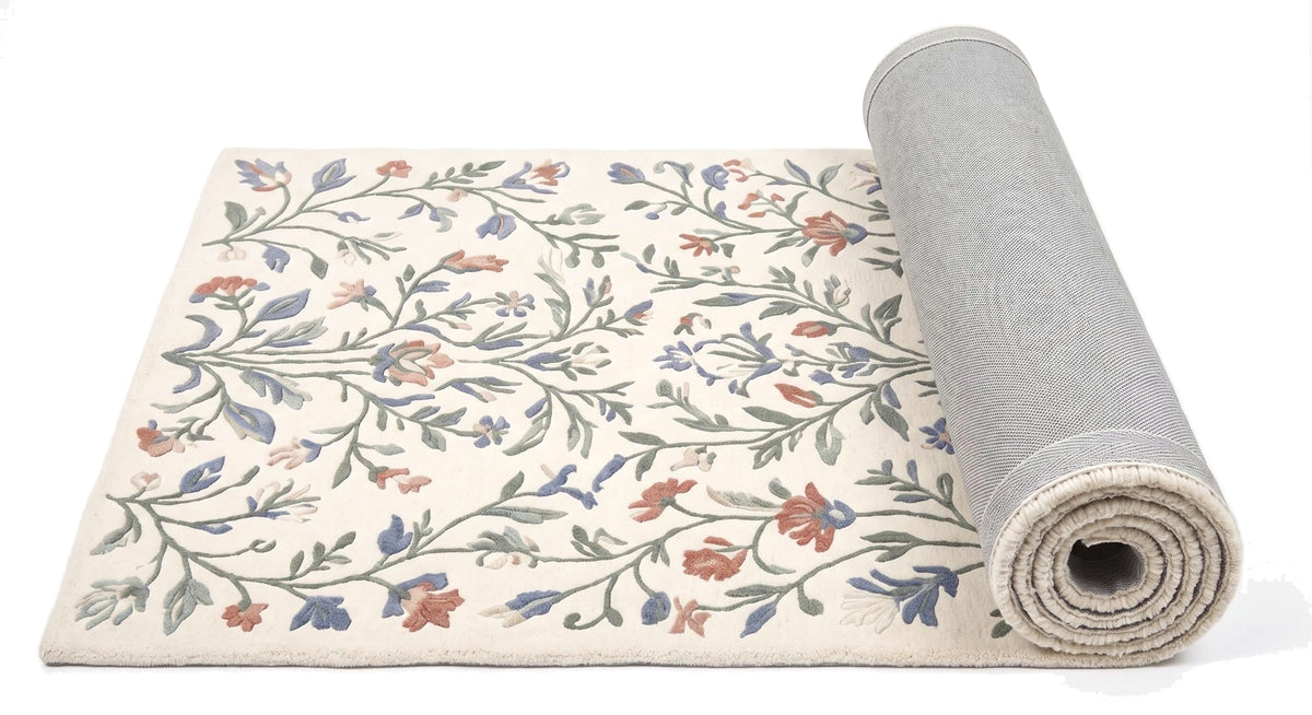 Le détail des motifs floraux ramifiés en poil coupé sur laine ivoire, et le dos gris du tapis roulé