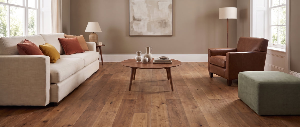 Intérieur chaleureux dévoilant un parquet en bois clair, canapé, fauteuil et table basse sans tapis au sol