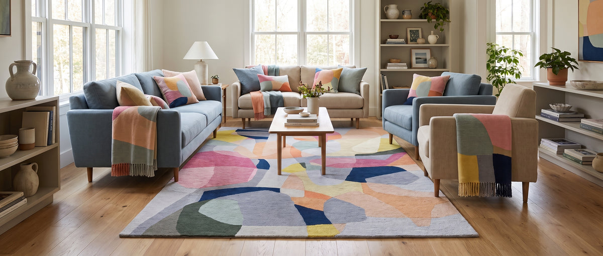 Ce tapis en laine fait main déploie des formes abstraites et des couleurs douces et vives dans un salon lumineux