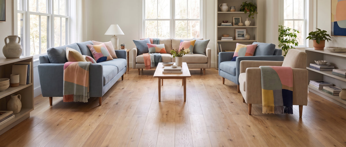 Salon lumineux au parquet clair et nu, meublé de canapés bleus et beiges, de tables et d'étagères décorées