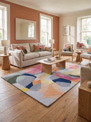 Des teintes vives et des formes organiques animent ce tapis rectangulaire en laine fait main dans un salon épuré