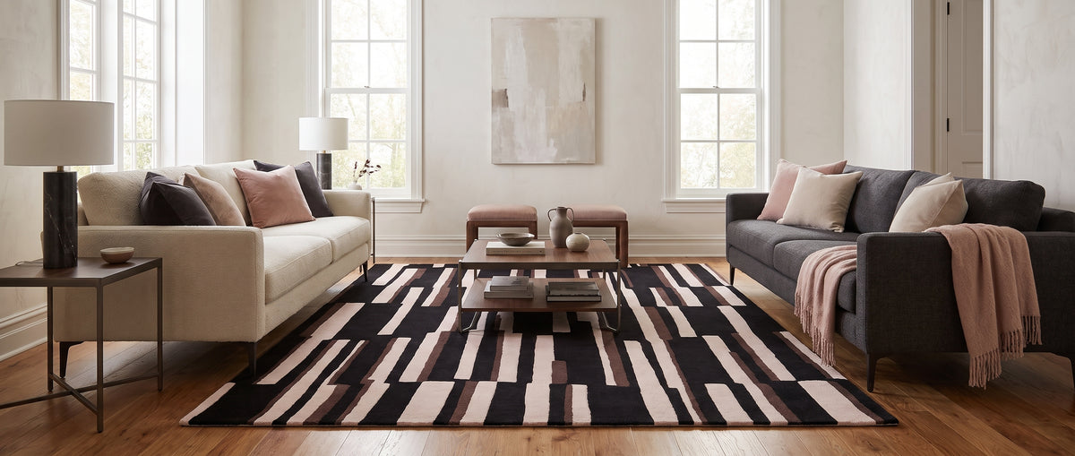 Le contraste du noir, de l'ivoire et du brun anime ce tapis en laine fait main, dans un salon moderne et lumineux