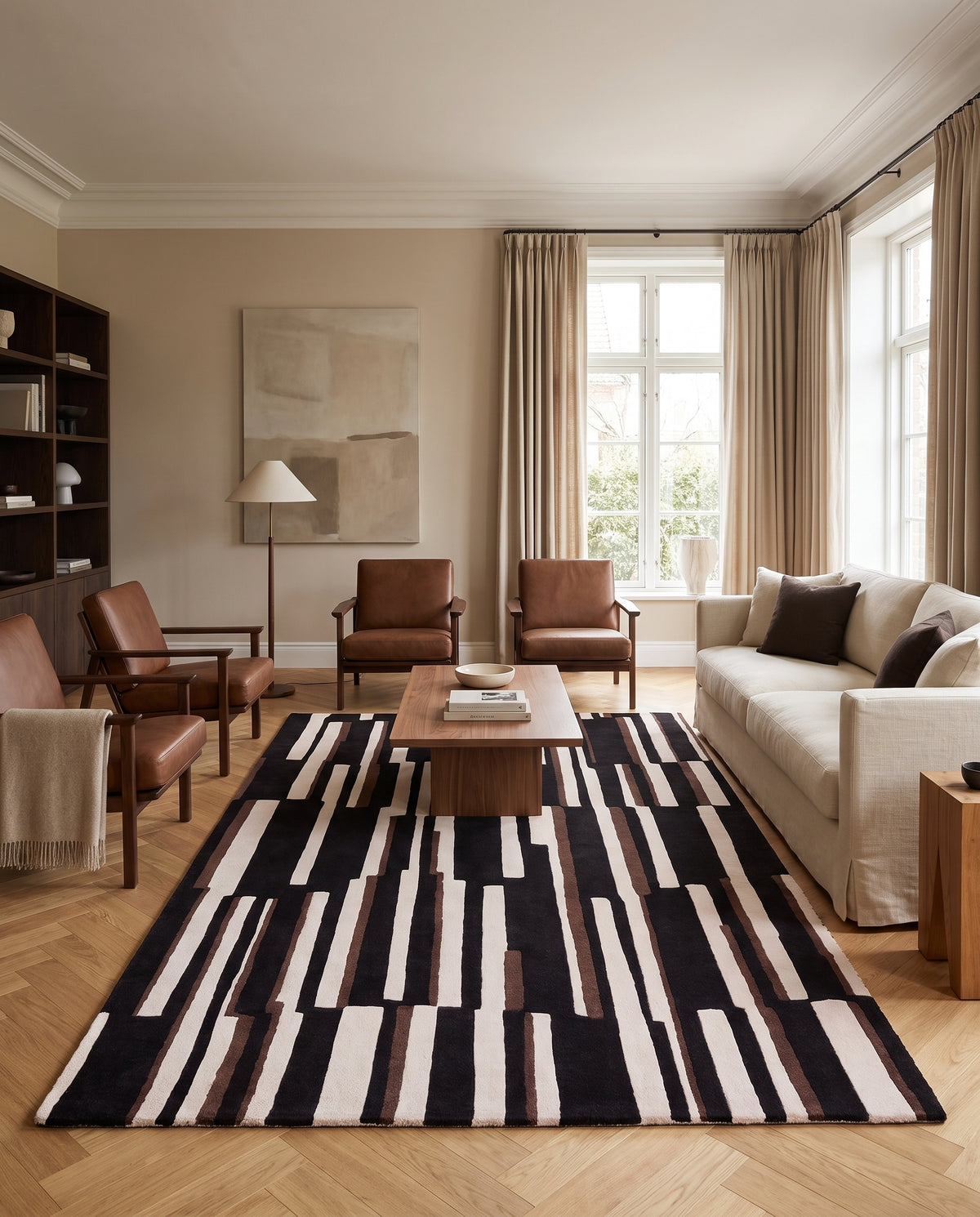 Des barres asymétriques noires, ivoire et brunes animent ce tapis en laine fait main dans un salon contemporain