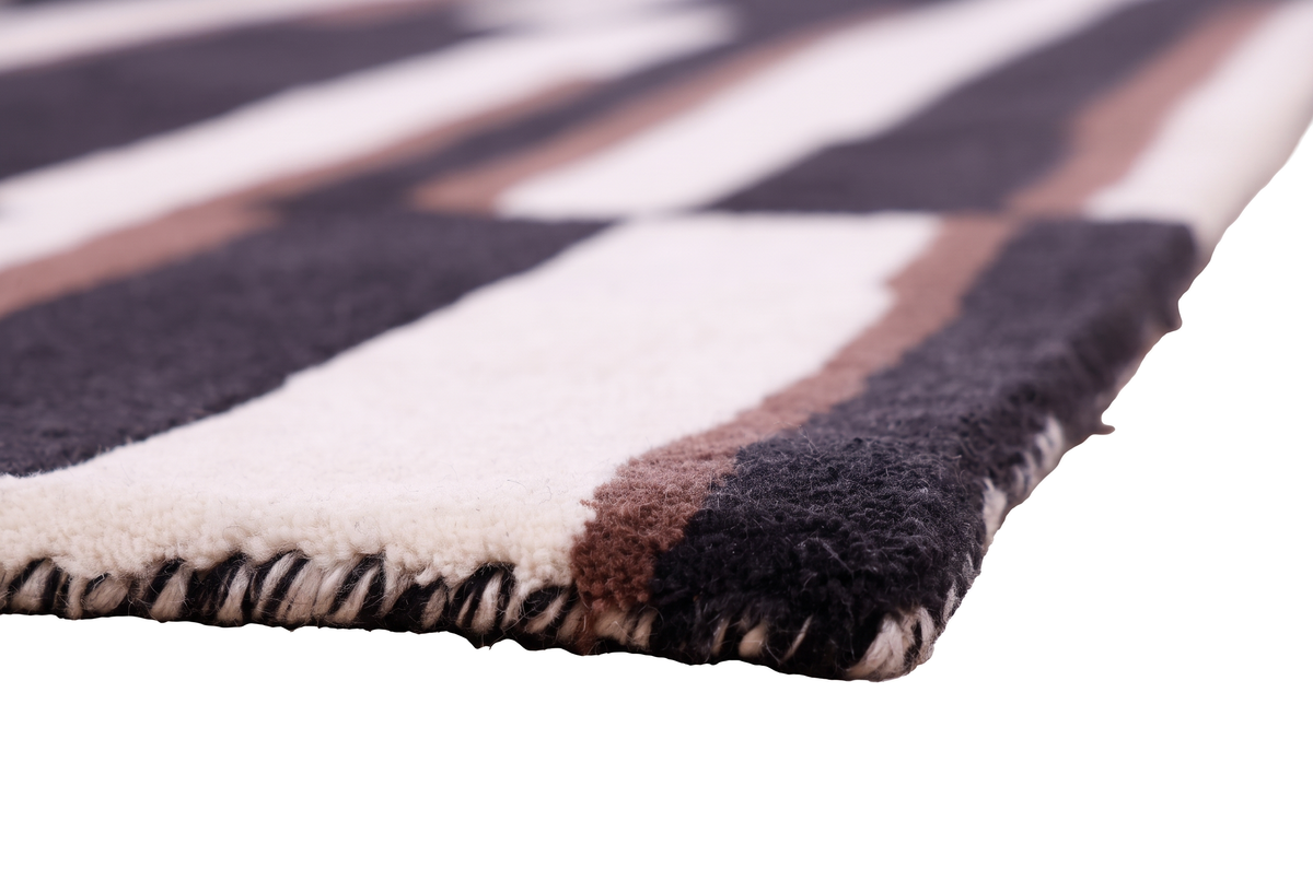 Le relief et la texture des laines ivoire, noire et brune d'un tapis fait main sont visibles en gros plan