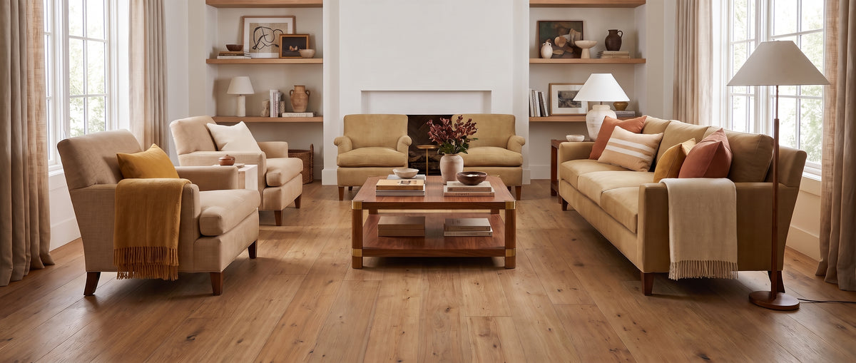 Sol en bois nu pour ce salon lumineux et élégant, meublé de canapés beiges et d'étagères décorées, sans tapis