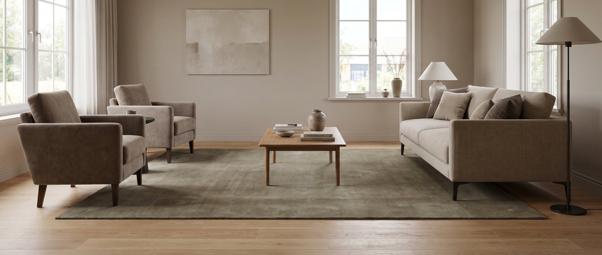 Des reflets subtils animent ce tapis rectangulaire en laine taupe fait main, au cœur d'un salon lumineux