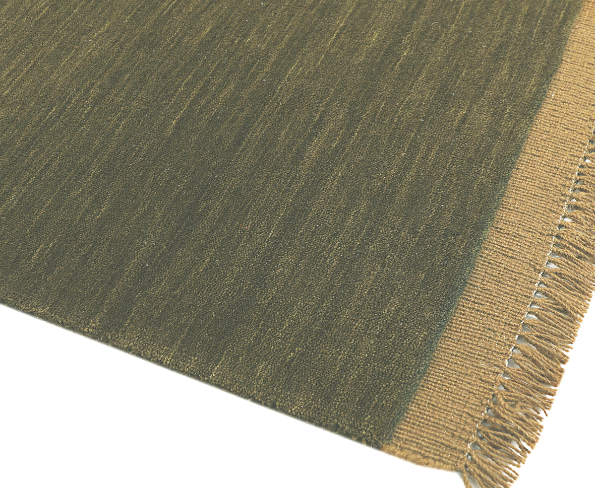 Le tissage strié de la laine vert olive se révèle avec le bord beige et les franges