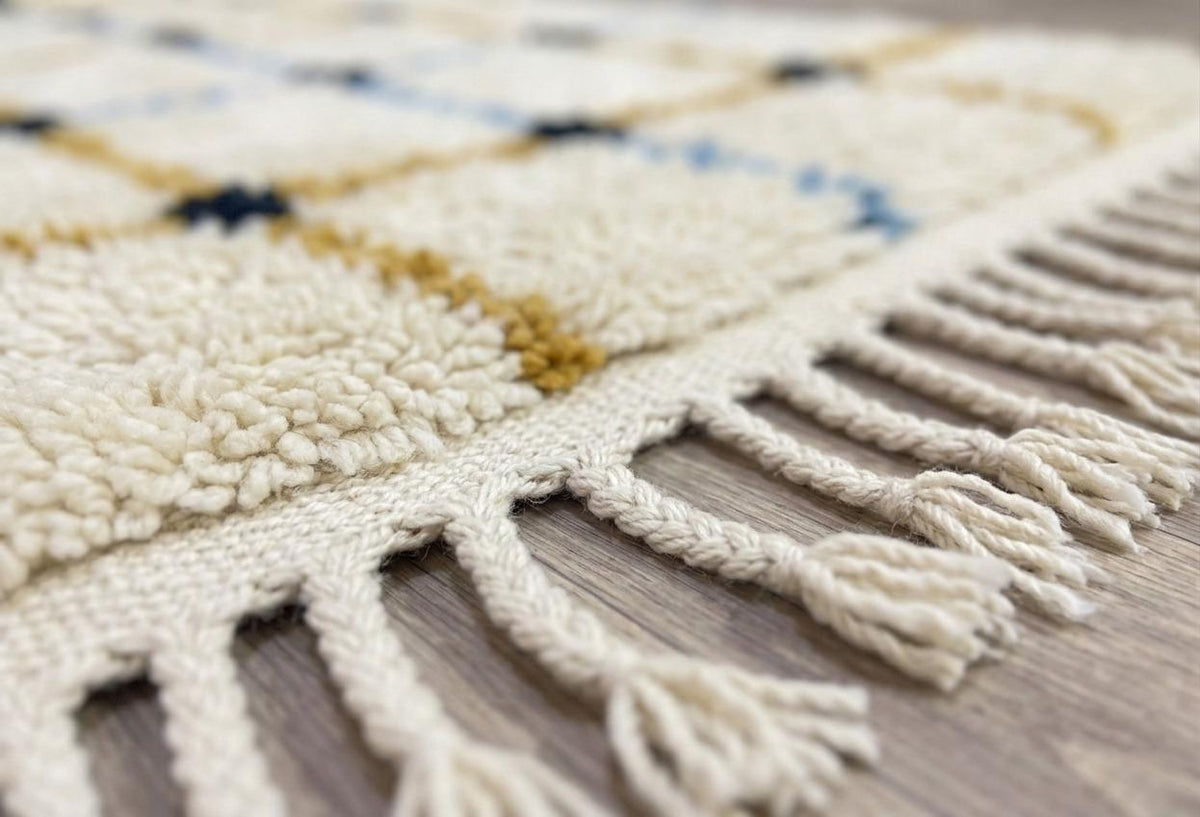 Gros plan sur les franges du tapis berbère Tafrin, écrues nouées en bas seulement, nouées à la main