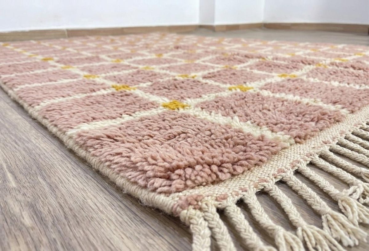 Gros plan sur le coin relevé du tapis berbère Tizwira, épaisseur du poil long et dos tissé à la main