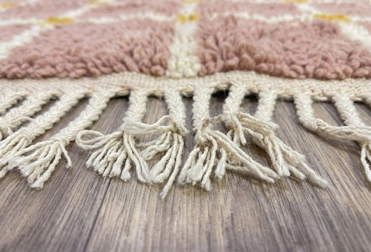 Gros plan sur les franges du tapis berbère Tizwira, écrues nouées, nouées à la main