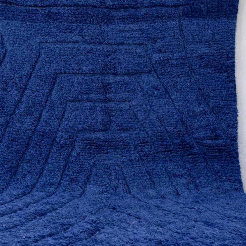Gros plan sur la laine du tapis berbère Tirelwa, laine de mouton au poil moyen, bleue
