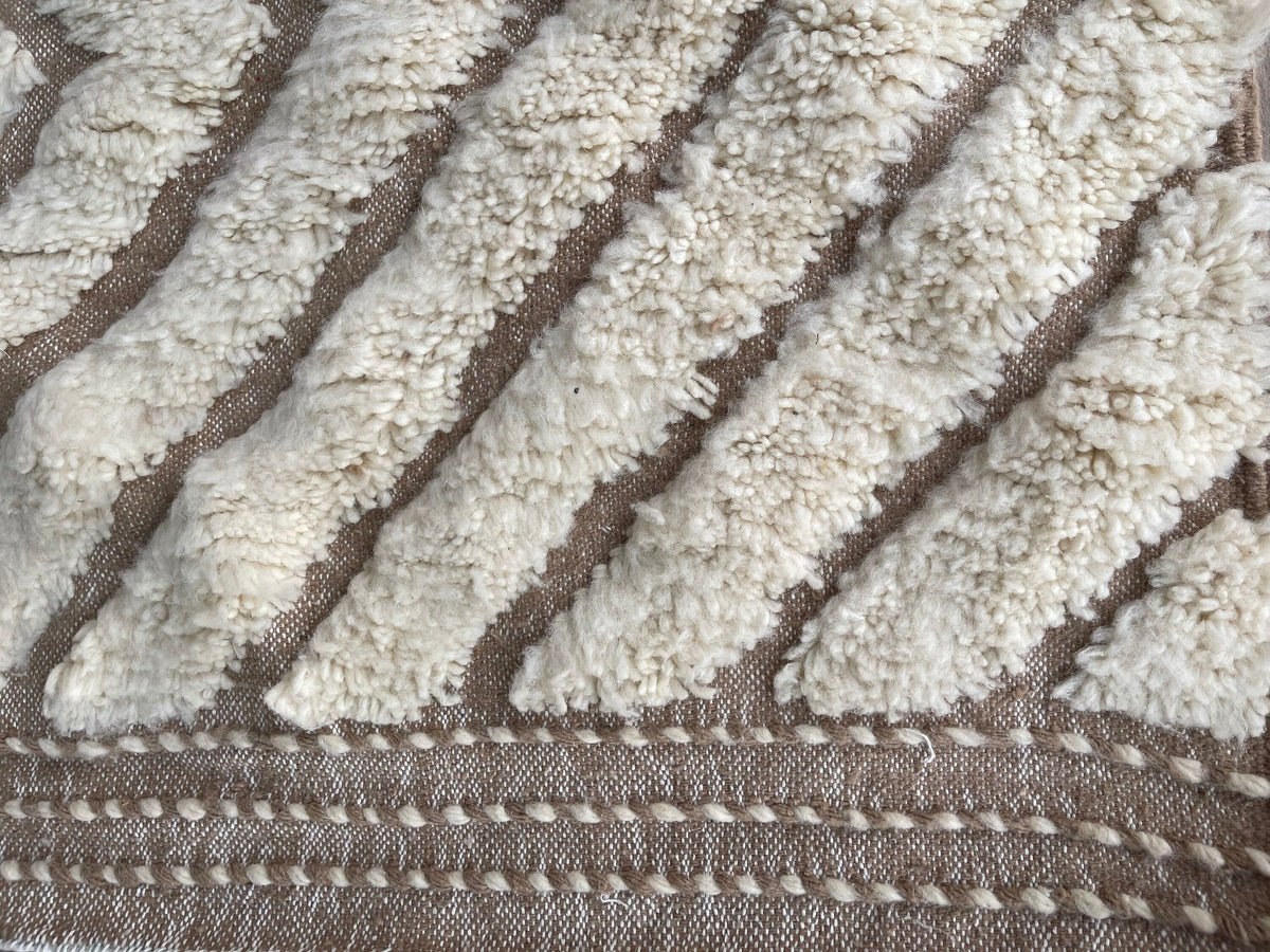 Gros plan sur le coin relevé du tapis berbère Amtoudi, angle du tapis et finition de la bordure