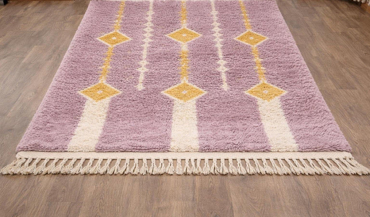 Tapis berbère à losanges mauve Mecissi posé au sol vu de côté, noué main au Maroc