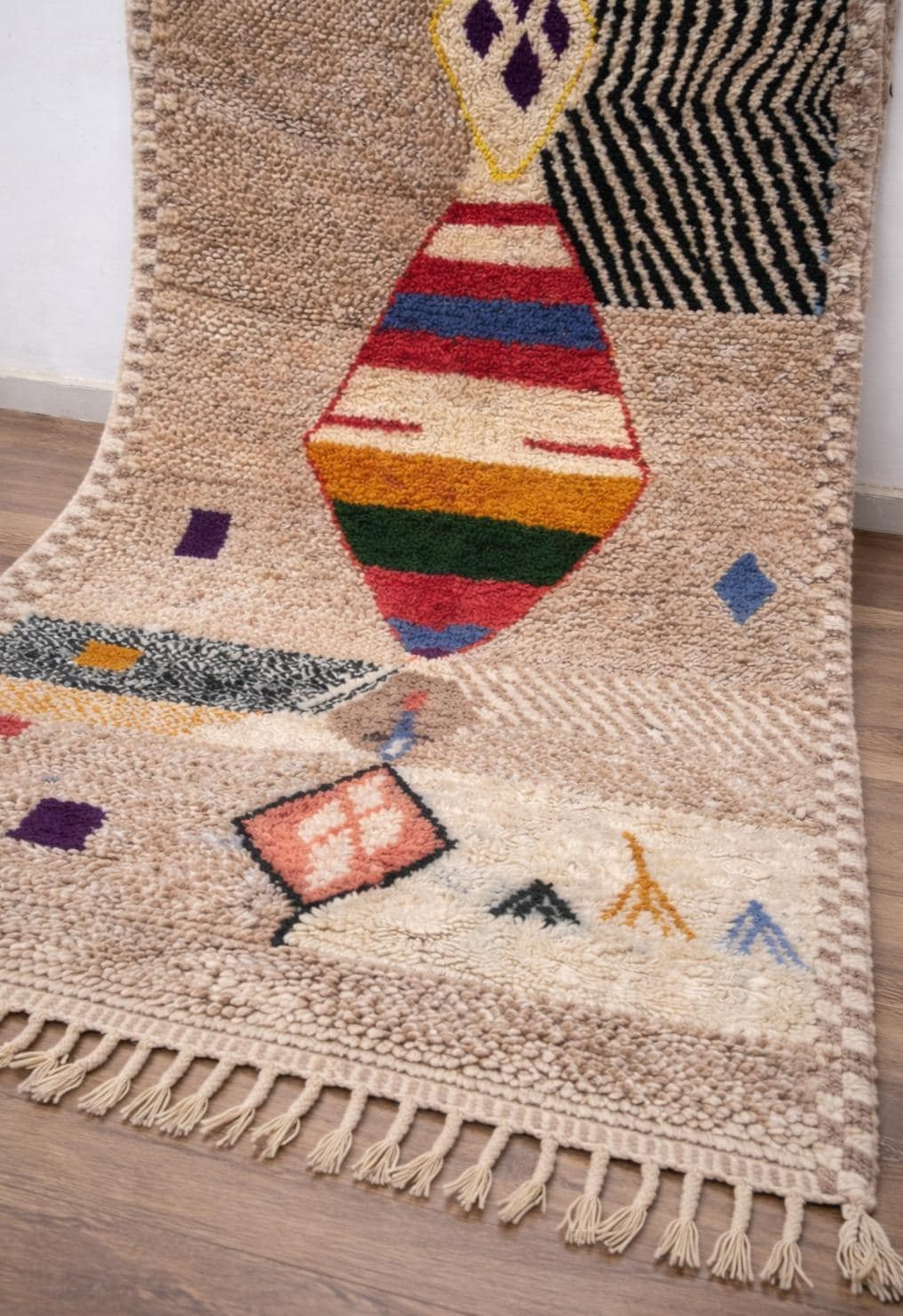 Gros plan sur un détail du tapis berbère Ahaggar, poil moyen et motif beige sable vus de près