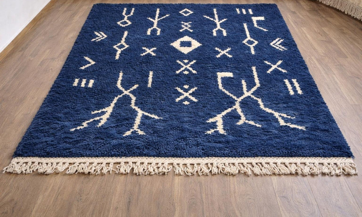 Tapis berbère à motifs bleu marine Ansegmir posé au sol vu en biais, noué main au Maroc
