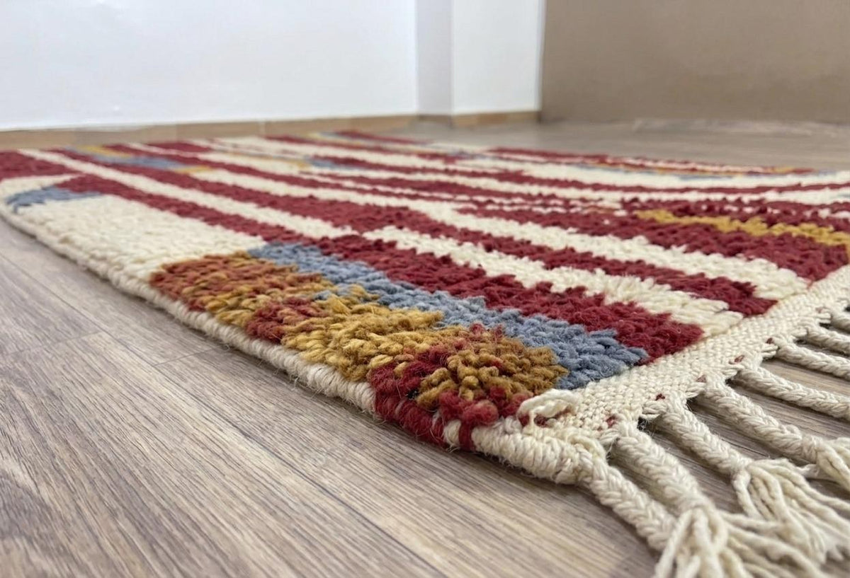 Gros plan sur le coin relevé du tapis berbère Tarouan, épaisseur du poil moyen et dos tissé à la main