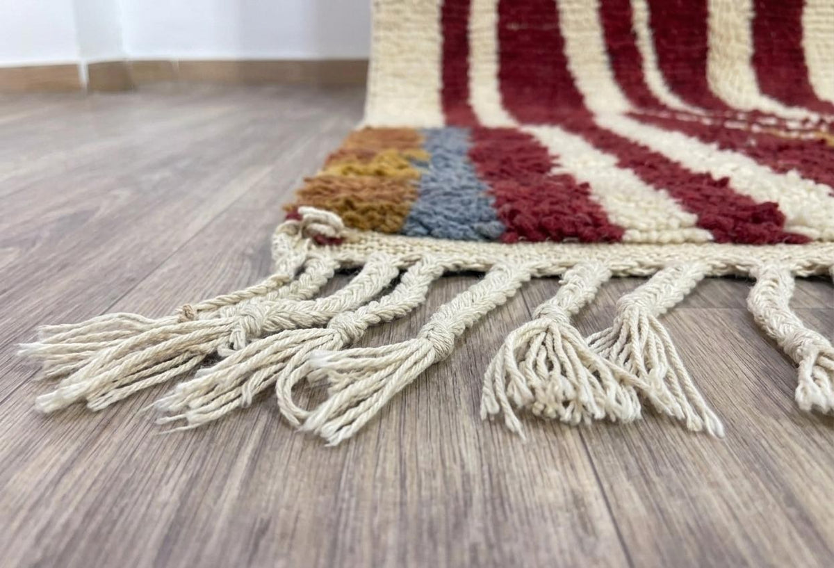 Gros plan sur les franges du tapis berbère Tarouan, écrues en bas seulement, nouées à la main