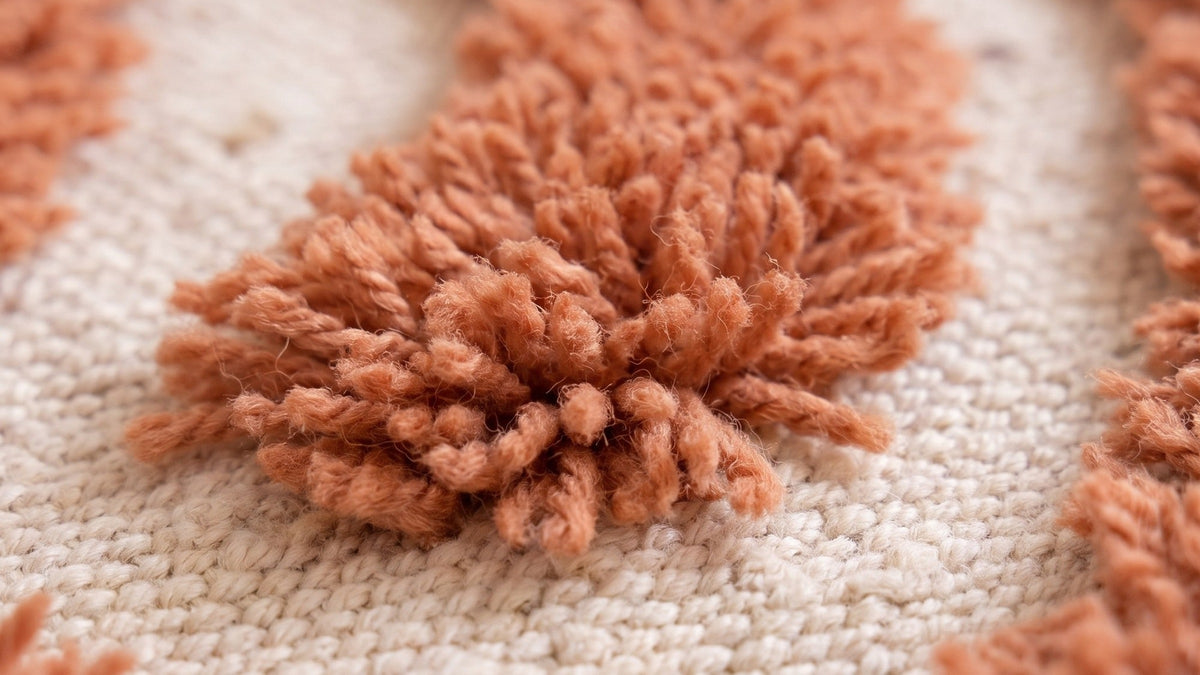 Gros plan sur la laine du tapis berbère Anmira, poil terracotta noué à la main