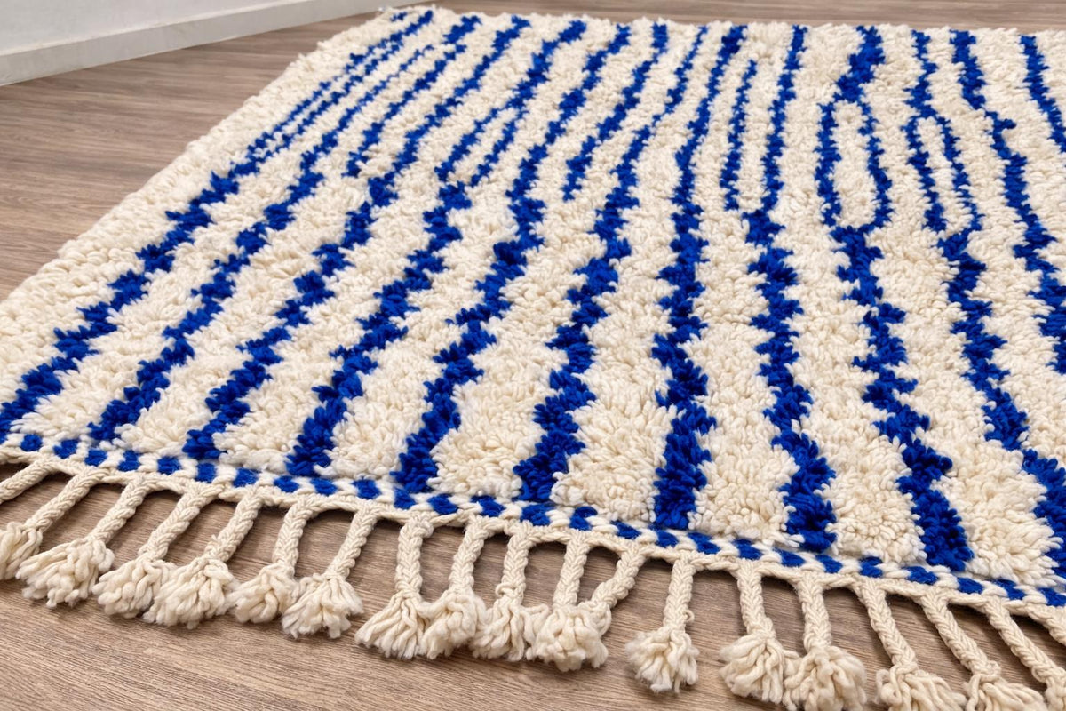 Gros plan sur les franges du tapis berbère Ageffur, écrues nouées à pompons, nouées à la main