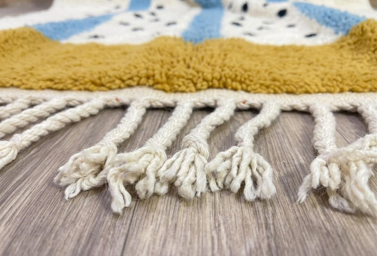 Gros plan sur les franges du tapis berbère Tadmil, écrues nouées en bas seulement, nouées à la main