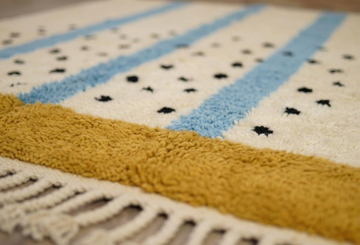Gros plan sur la laine du tapis berbère Tadmil, laine de mouton au poil long, blanche et bleu ciel