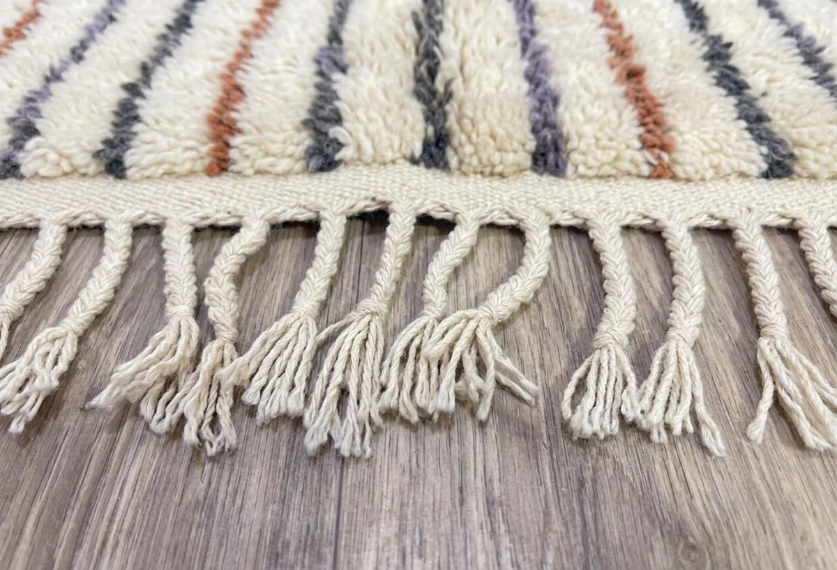 Gros plan sur les franges du tapis berbère Tinzar, écrues nouées, nouées à la main