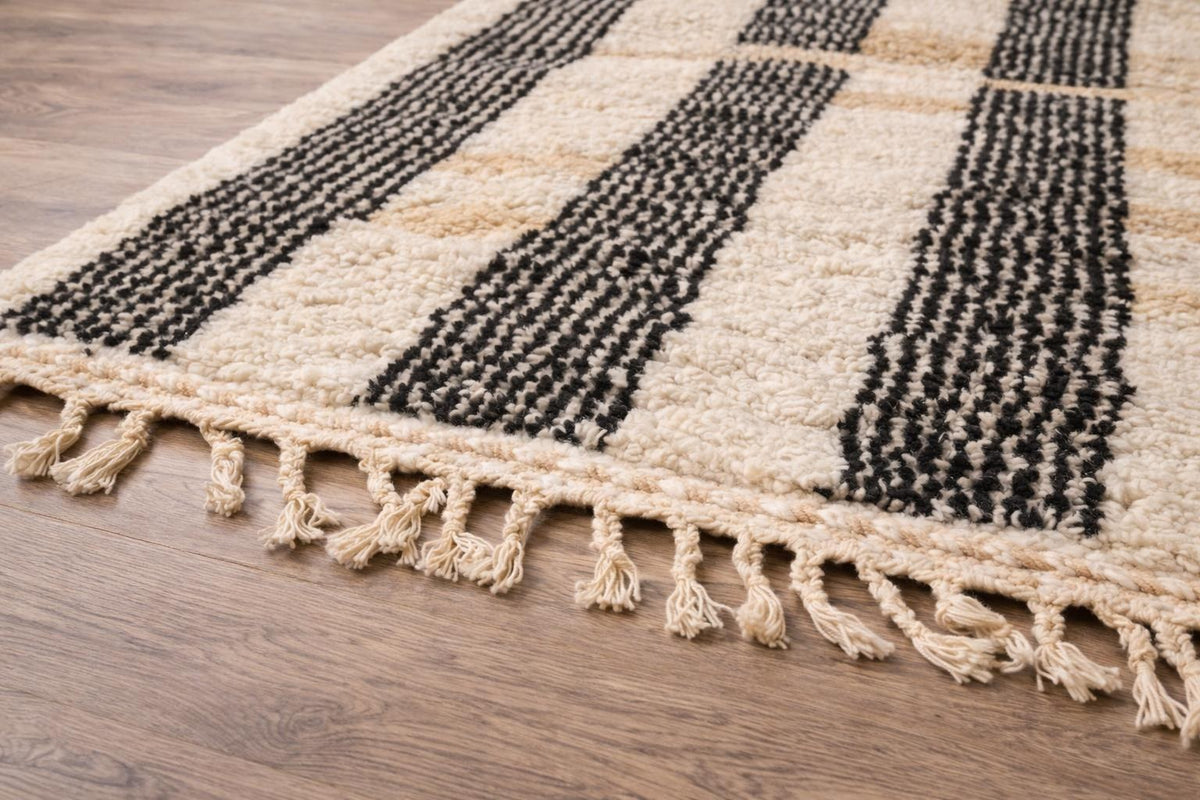 Gros plan sur les franges du tapis berbère Ighed, écrues nouées en bas seulement, nouées à la main