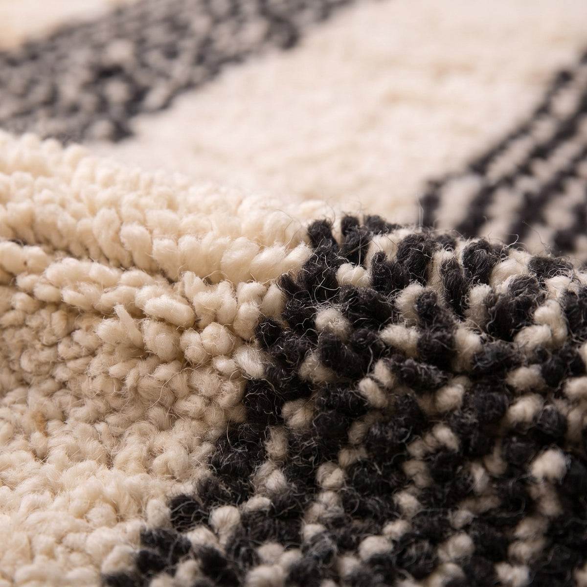 Gros plan sur un motif du tapis berbère Ighed, fond écru à poil moyen, quatre larges bandes