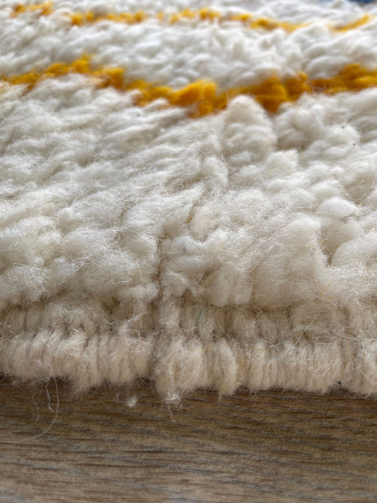 Close-up of the turned-up corner of the Fenzar Berber rug, depth of the long pile and hand-woven back