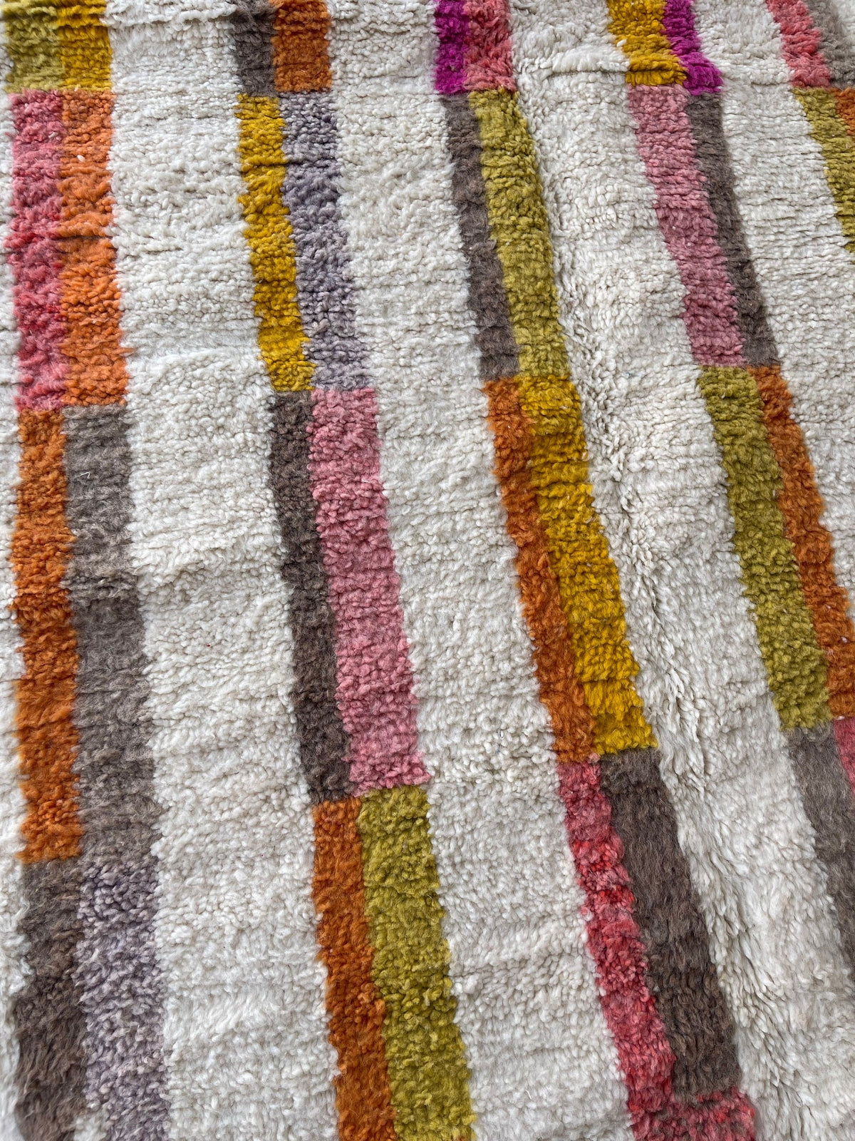 Close-up of the wool of the Fenzar Berber rug, sheep's wool with a long pile, white and multicolored