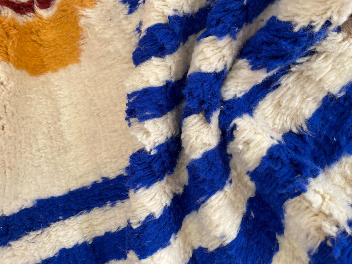 Close-up of a detail on the Zilmar Berber rug, long pile and blue and orange pattern up close