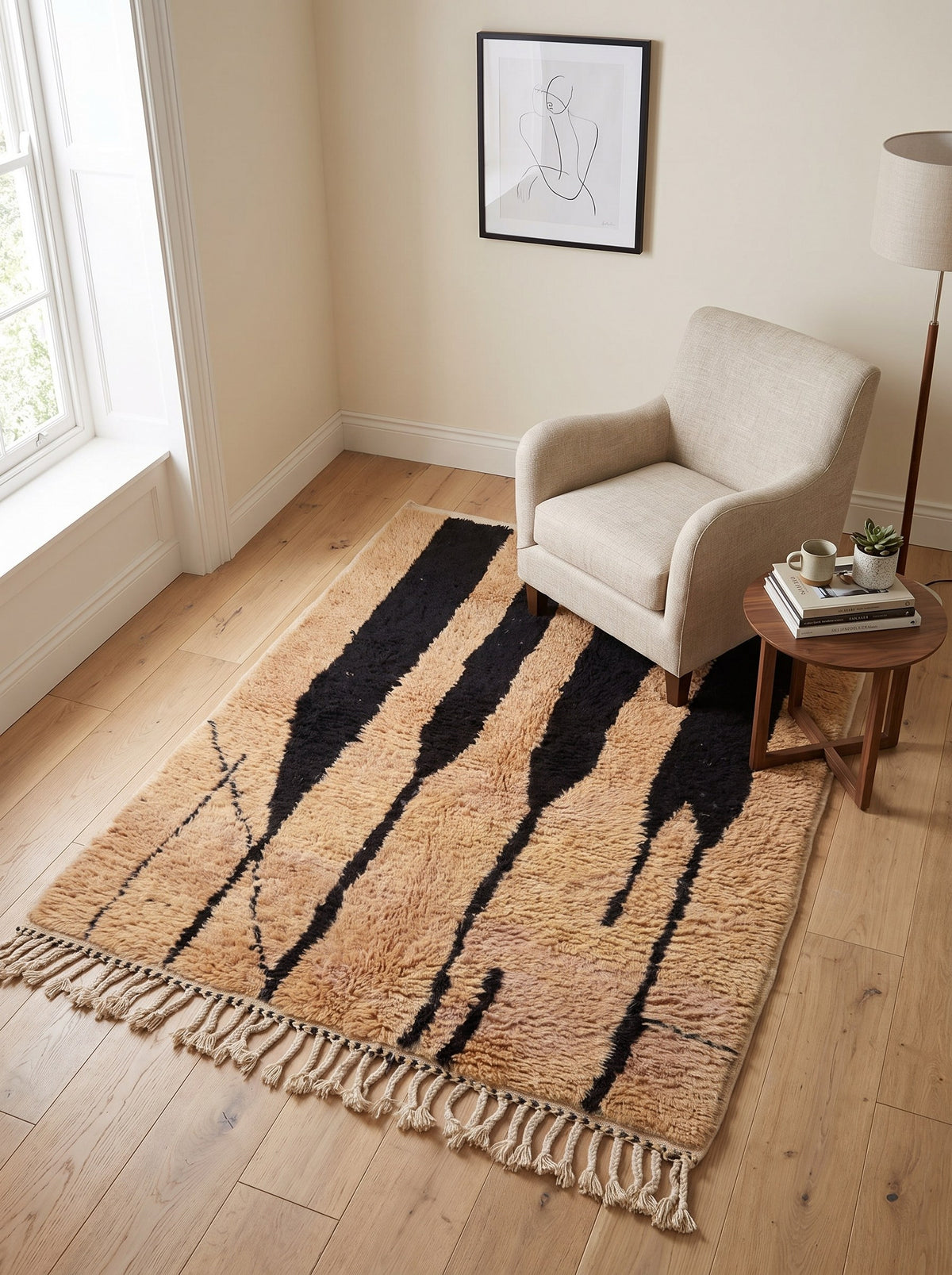 Tapis berbère à rayures camel et noir Tazroun dans un coin lecture, noué main au Maroc