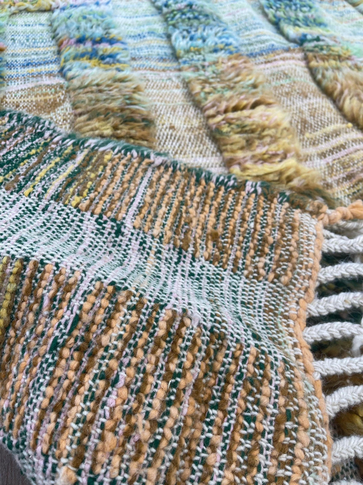 Gros plan sur les franges du tapis berbère Tissa, écrues nouées en bas, nouées à la main