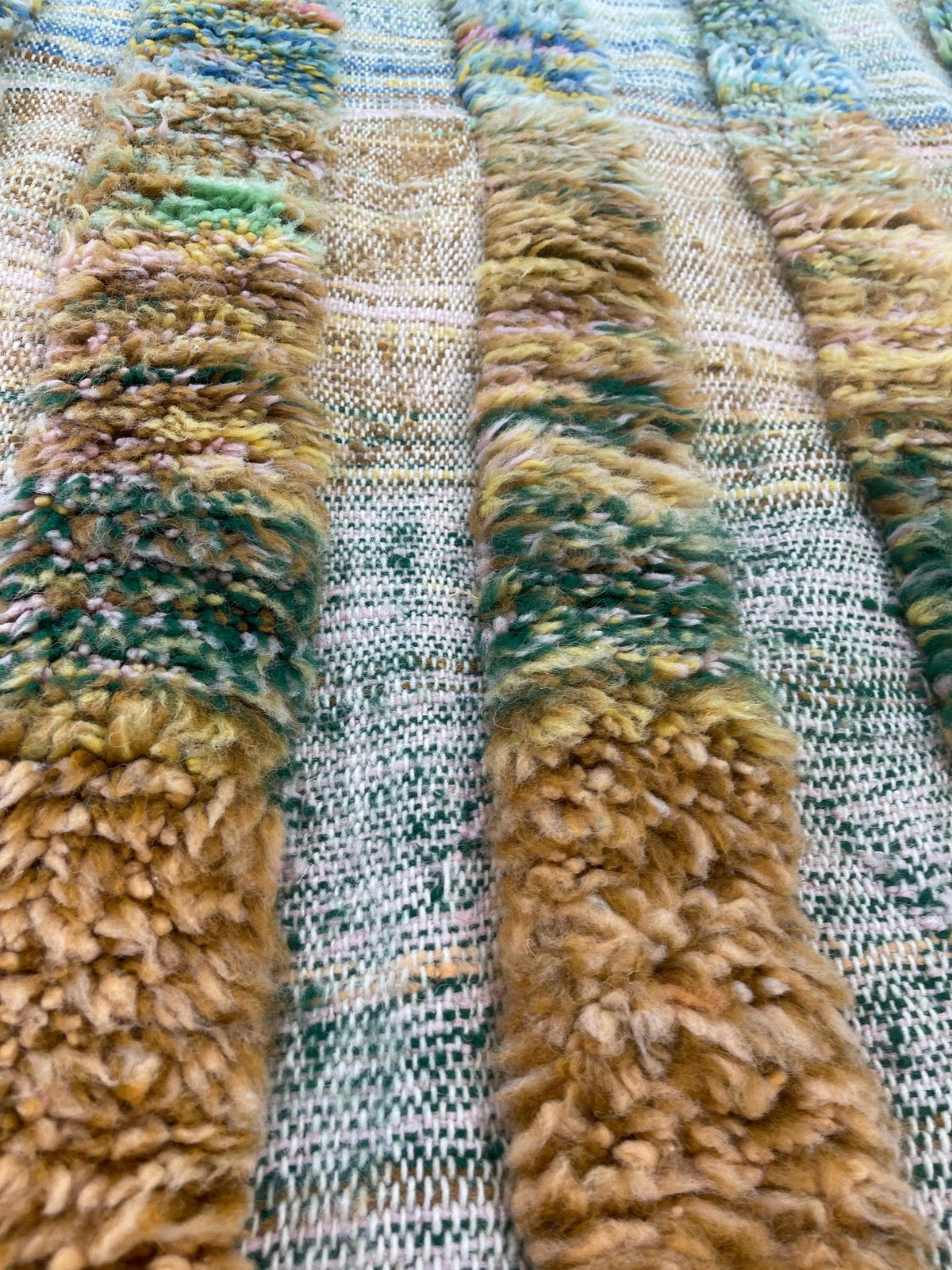 Gros plan sur la laine du tapis berbère Tissa, nœuds serrés et tracé du motif de près