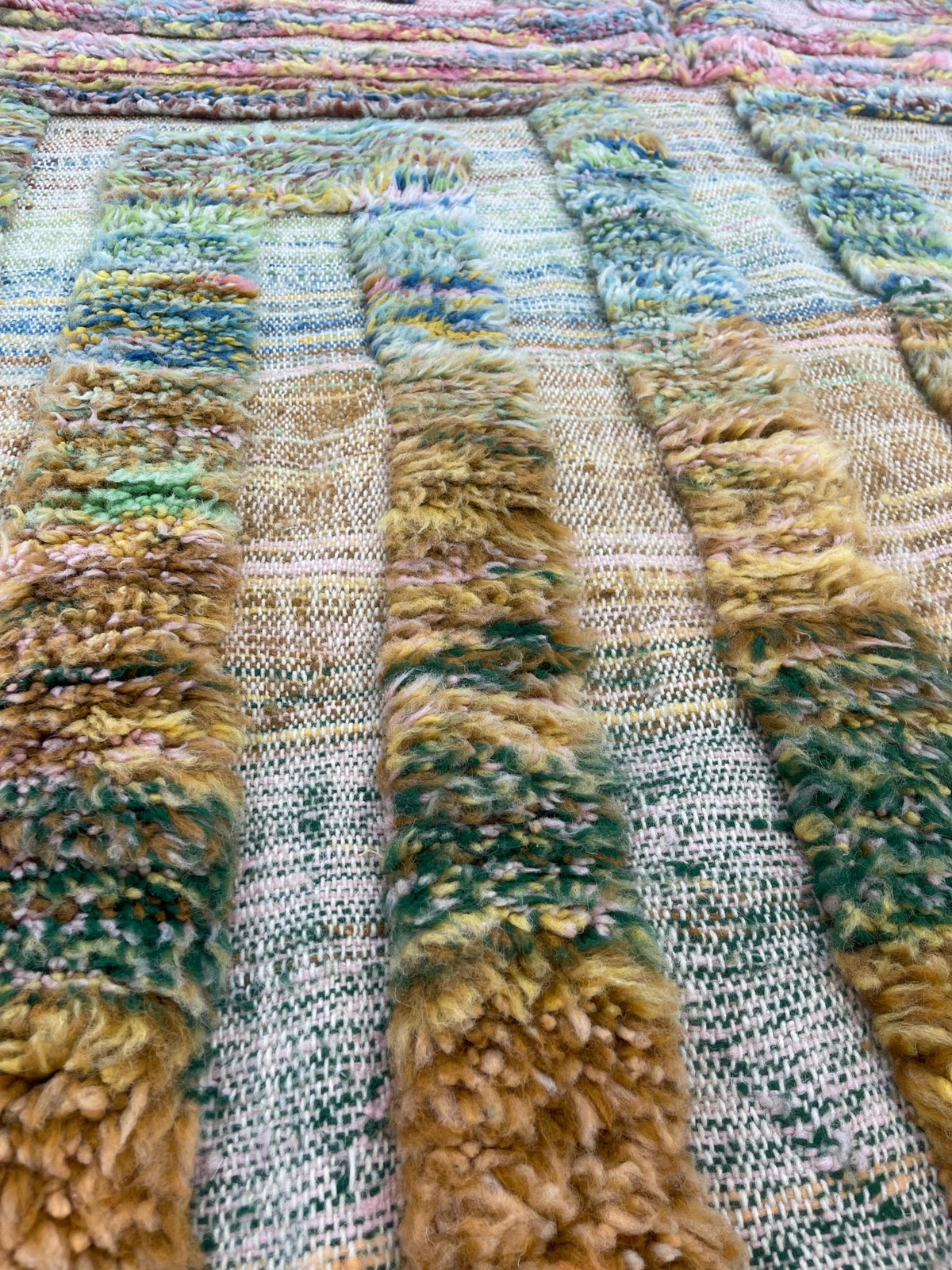 Gros plan sur un détail du tapis berbère Tissa, poil moyen et motif multicolore vus de près