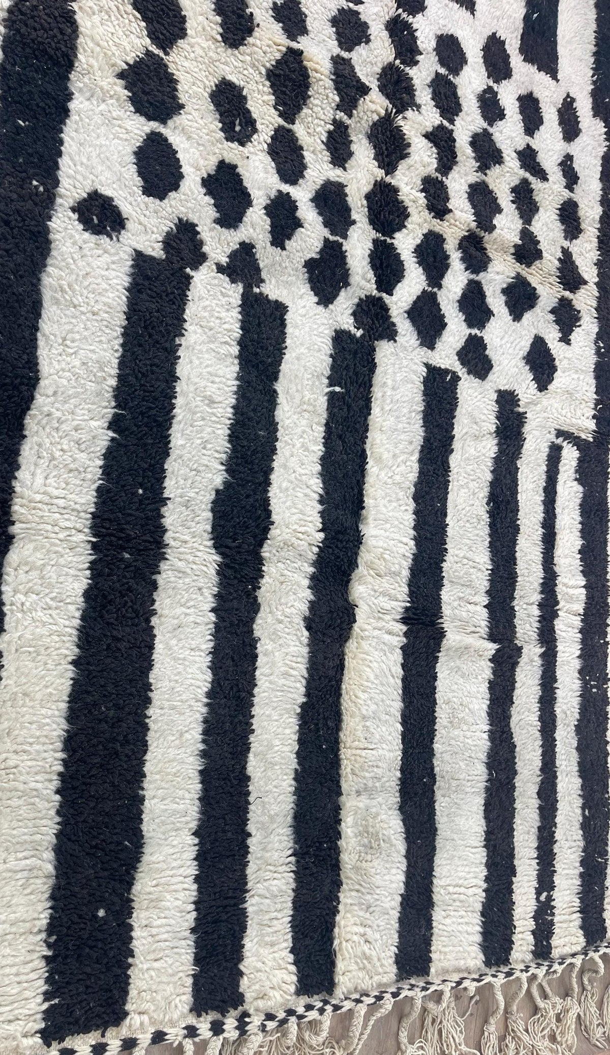 Gros plan sur un détail du tapis berbère Igherm, nuances de la laine et du motif de près