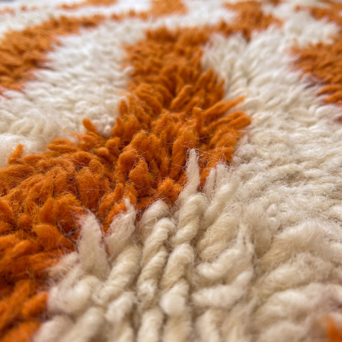 Close-up of a motif on the Imider Berber rug, ivory long-pile ground, eight orange stripes