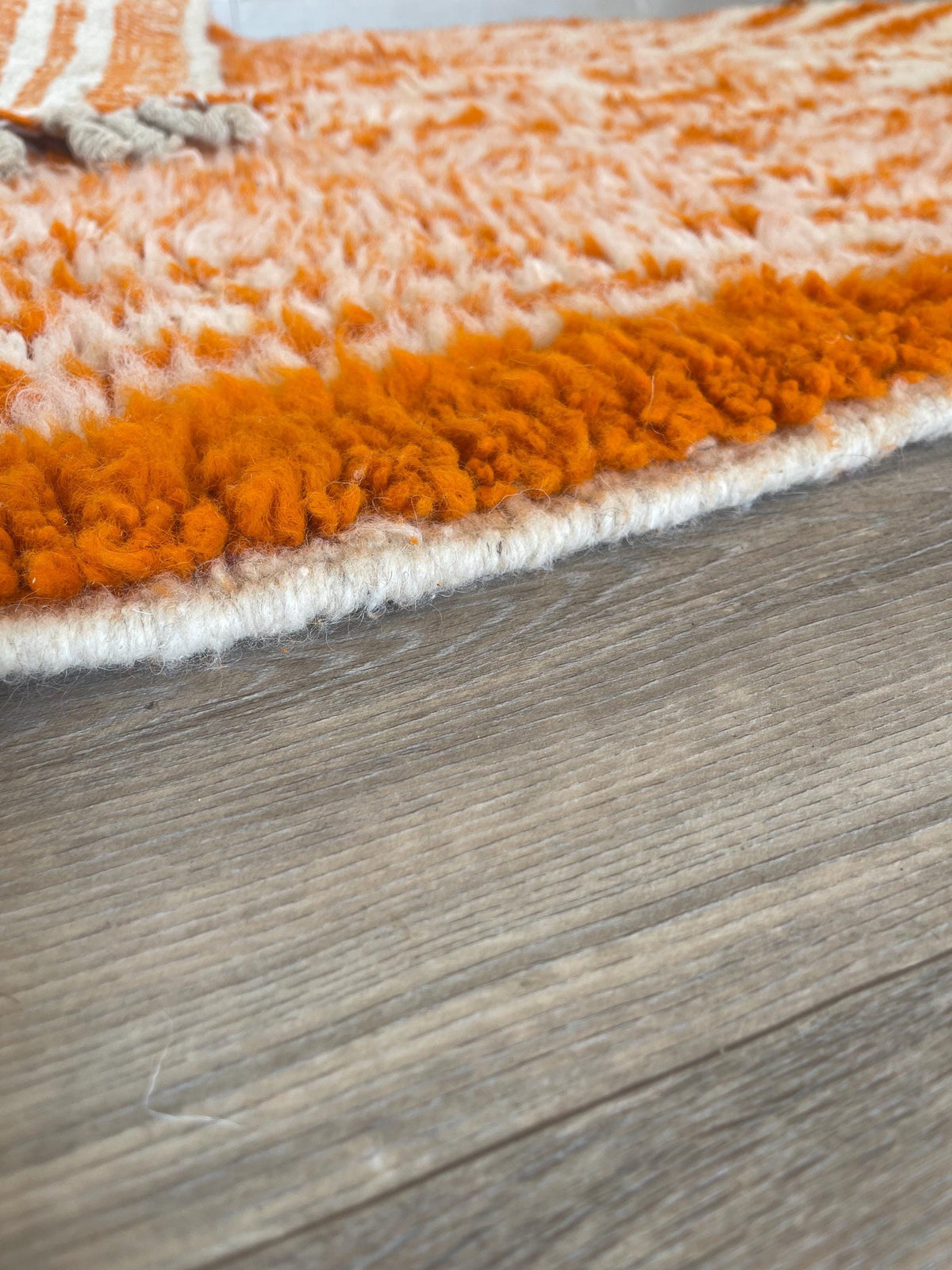 Close-up of the turned-up corner of the Iknioun Berber rug, thickness of the long pile and hand-woven back
