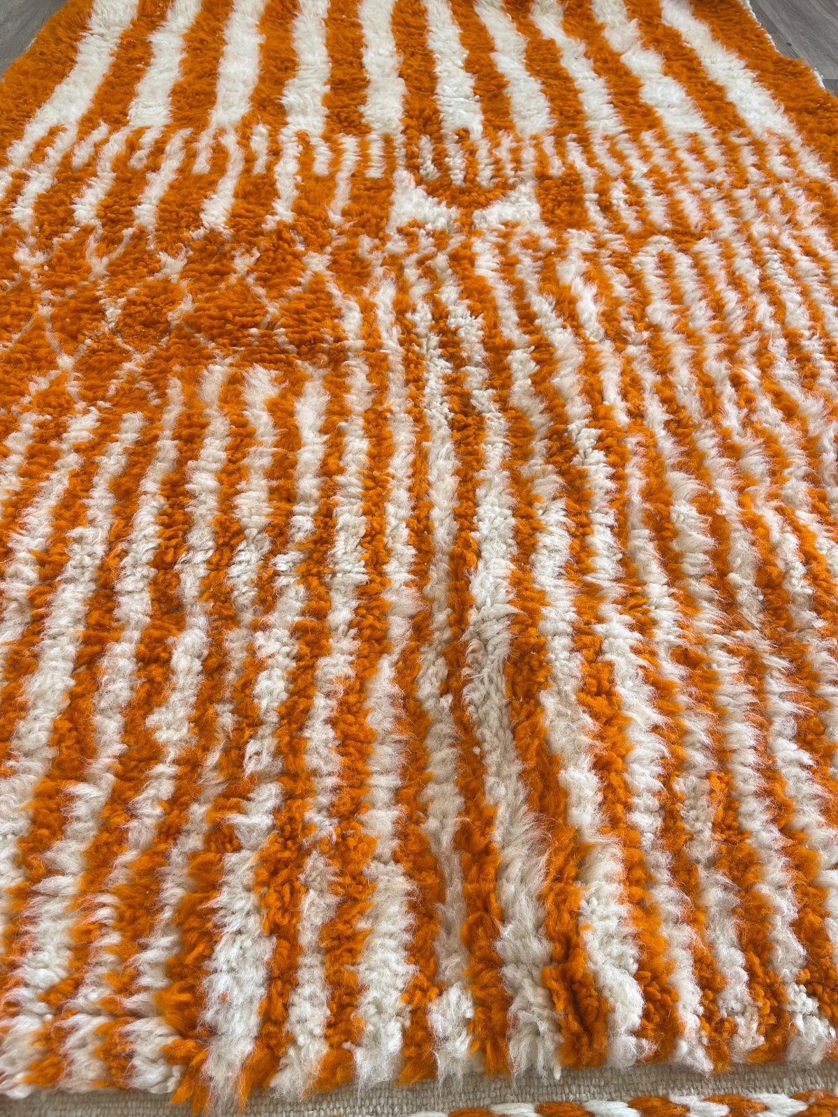 Close-up of a detail on the Iknioun Berber rug, long pile and pattern in orange seen up close