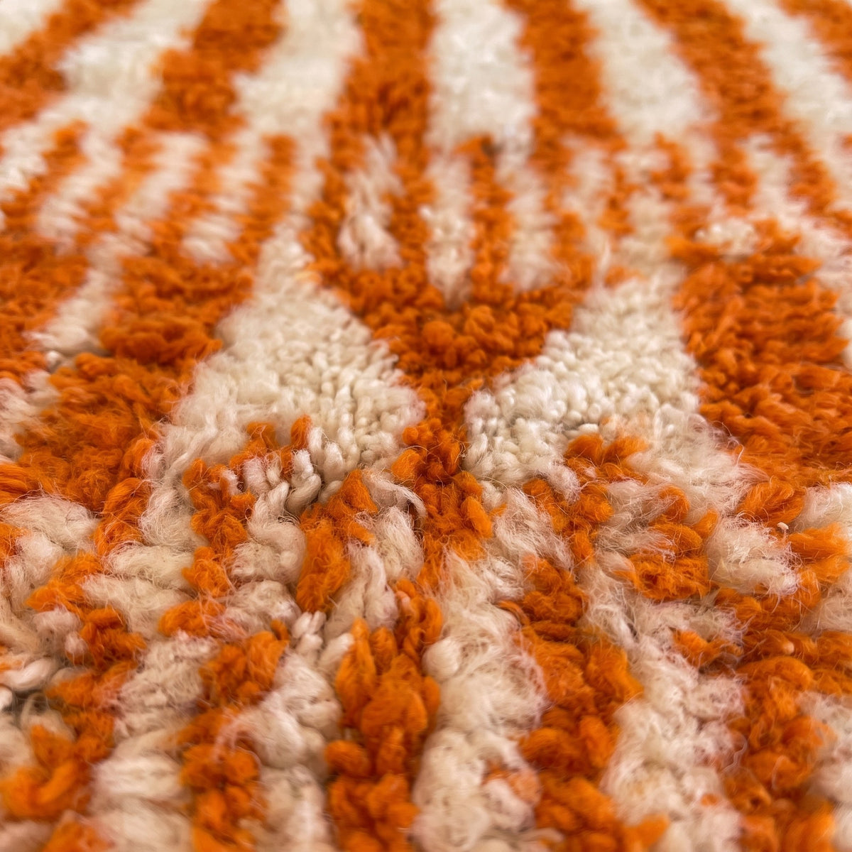 Close-up of a motif on the Iknioun Berber rug, orange sides, eleven vertical orange stripes at the top
