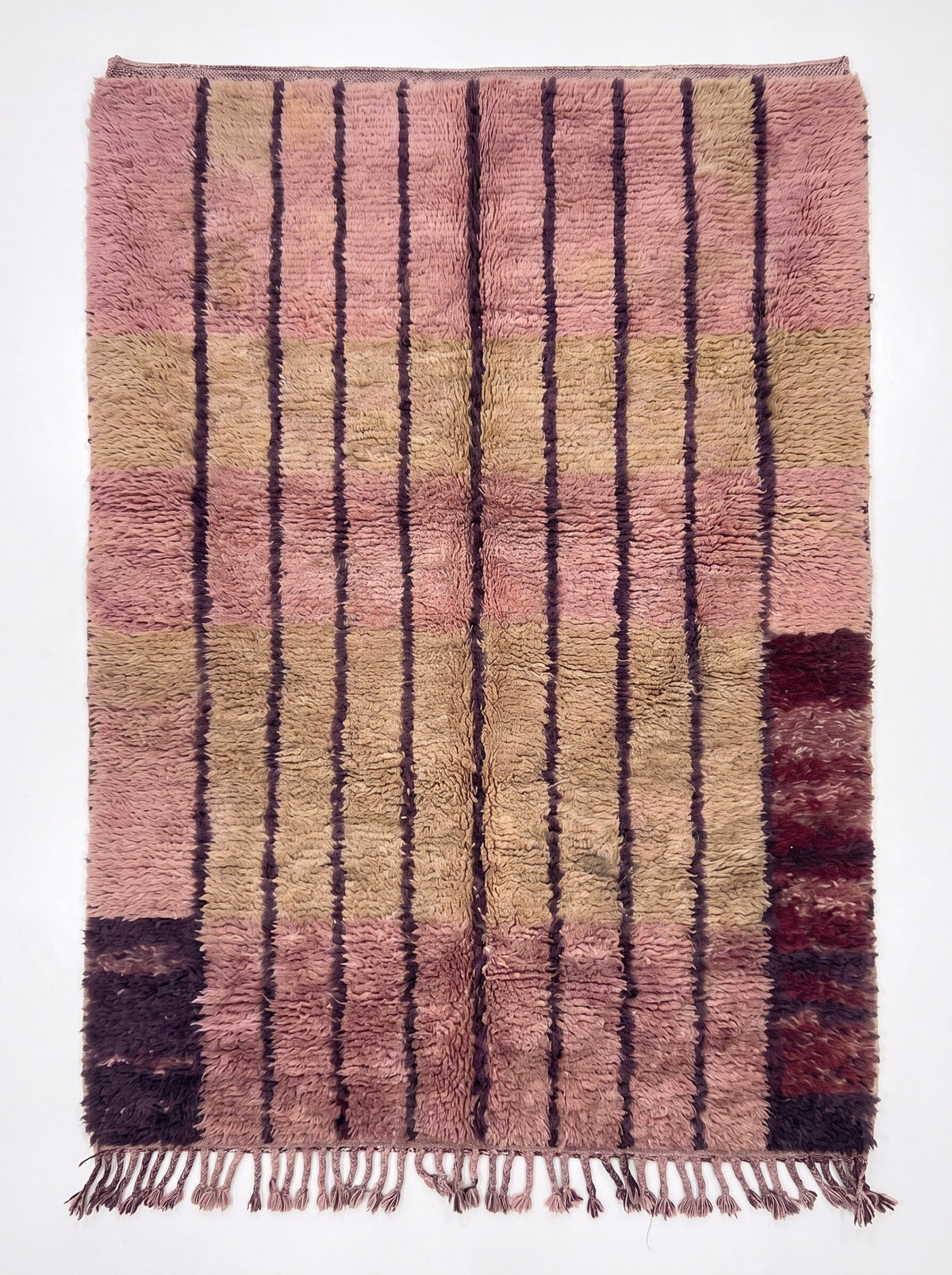 Tapis berbère à rayures rose Tadefi vu à plat, fond rose fané à poil long, franges rose prune nouées en bas seulement