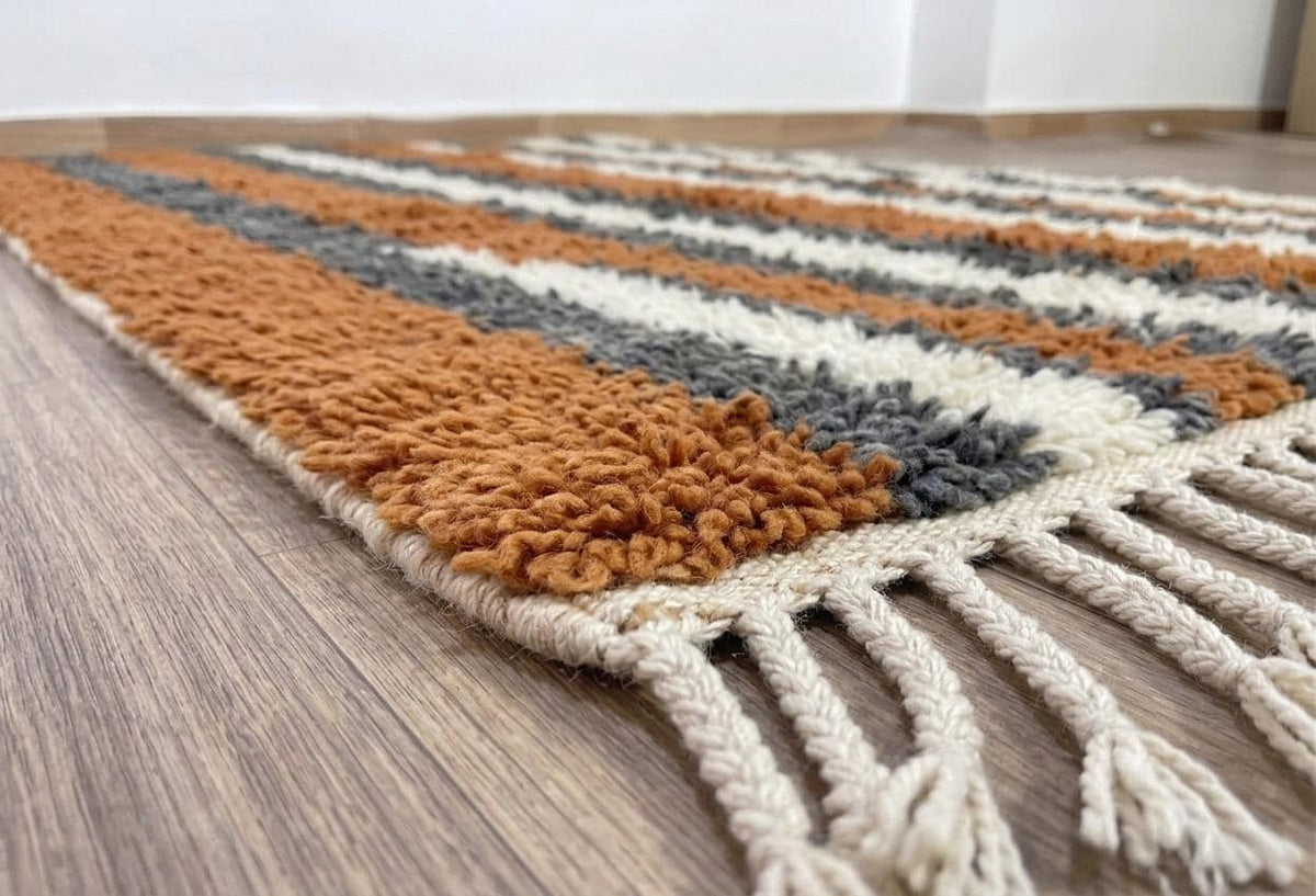 Gros plan sur le coin relevé du tapis berbère Ribab, épaisseur du poil long et dos tissé à la main