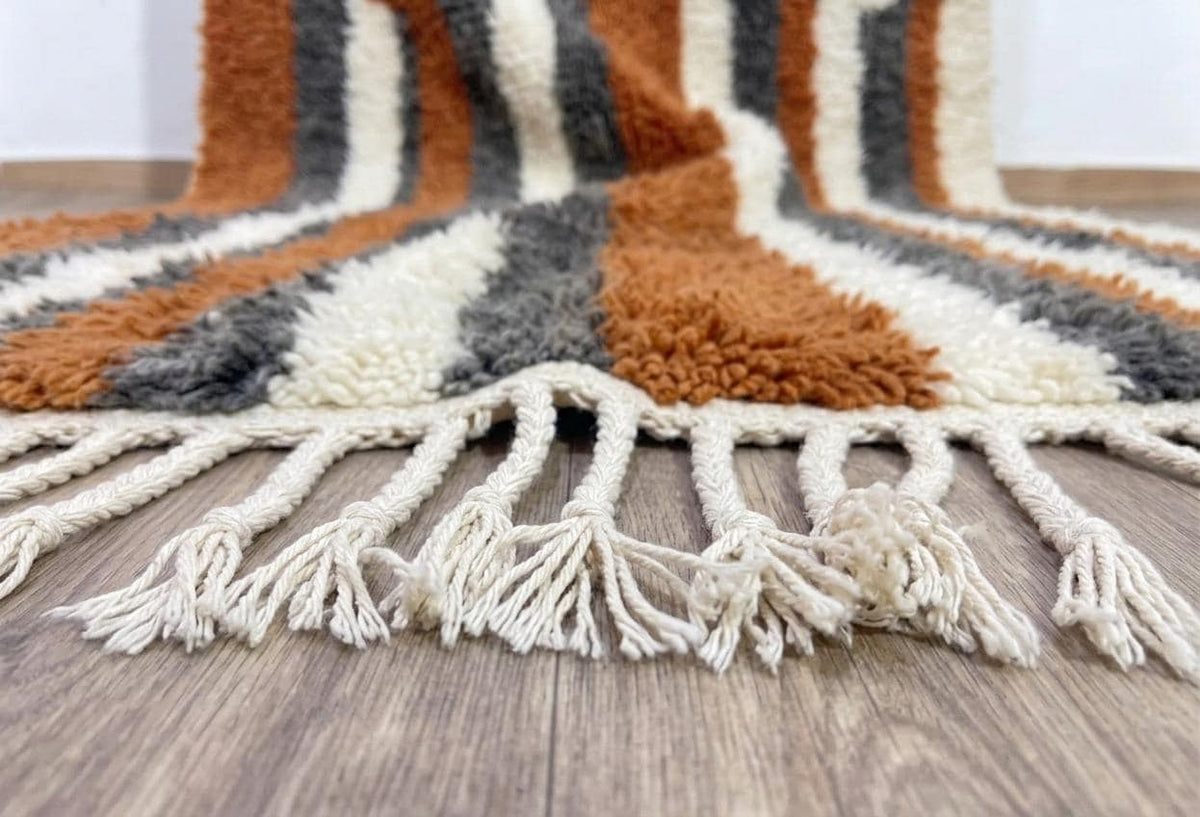 Gros plan sur les franges du tapis berbère Ribab, écrues torsadées, nouées à la main