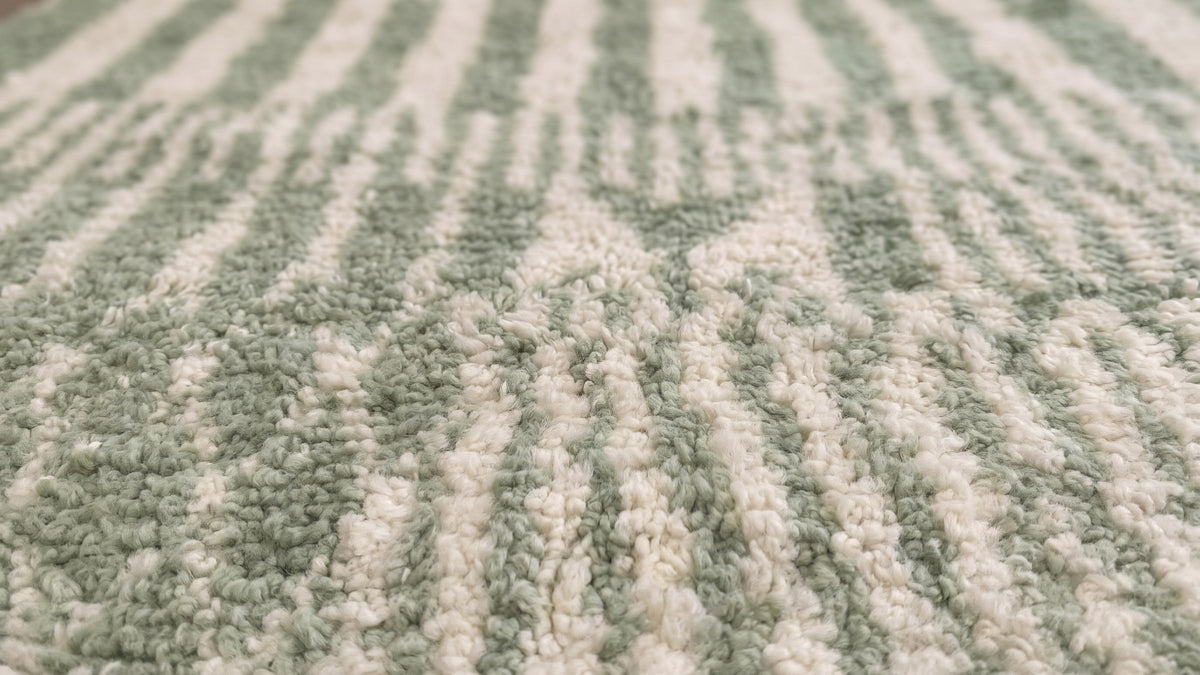 Gros plan sur la laine du tapis berbère Tiddas, poil vert sauge noué à la main