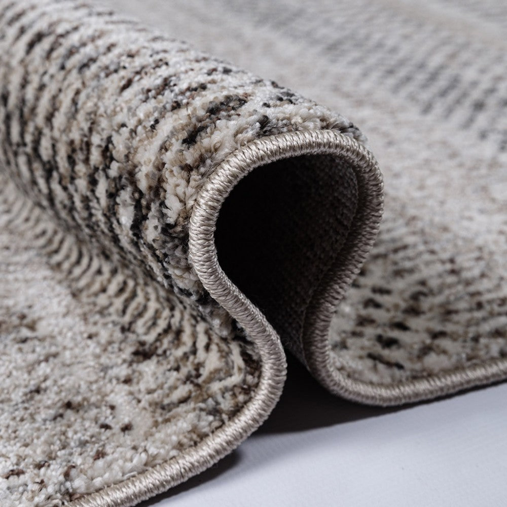 Tapis enroulé avec une texture moelleuse à motifs abstraits mouchetés beige, crème et marron foncé, bord ourlé