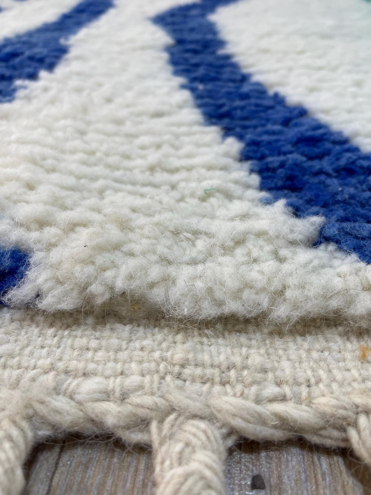 Gros plan sur les franges du tapis berbère Mezgal, nouées à la main sur la chaîne de coton