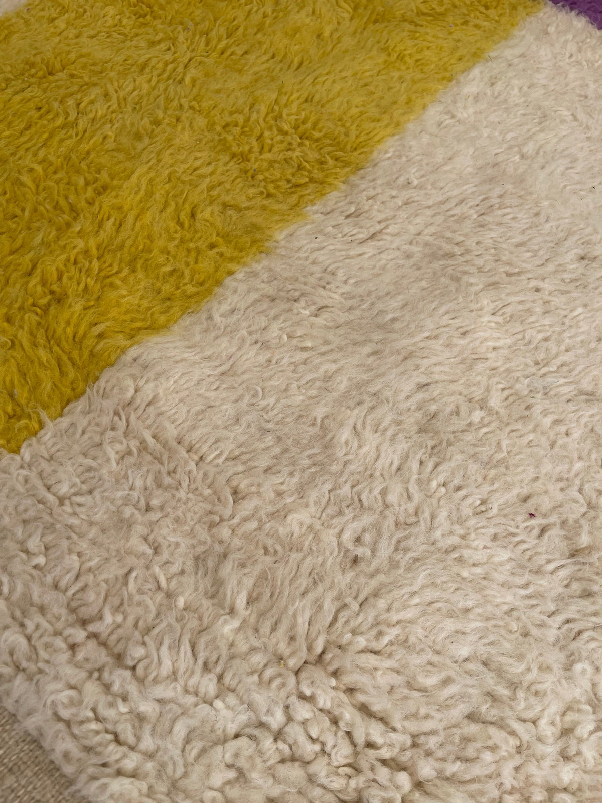 Gros plan sur la laine du tapis berbère Tahala, relief de la laine et du motif à la lumière